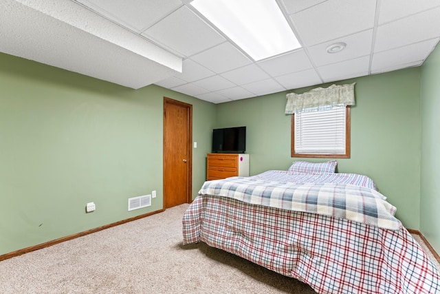 bedroom with a drop ceiling, carpet flooring, visible vents, and baseboards