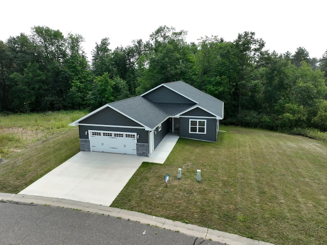 view of front of home featuring a garage, stone siding, driveway, and a front lawn