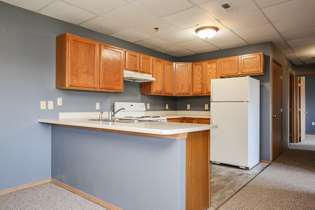 kitchen featuring a peninsula, white appliances, under cabinet range hood, and light countertops