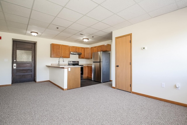 kitchen featuring brown cabinetry, a peninsula, stainless steel appliances, light countertops, and dark carpet