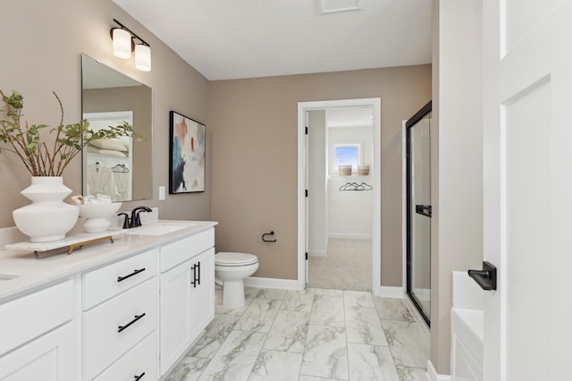 bathroom with marble finish floor, double vanity, a sink, a shower stall, and baseboards