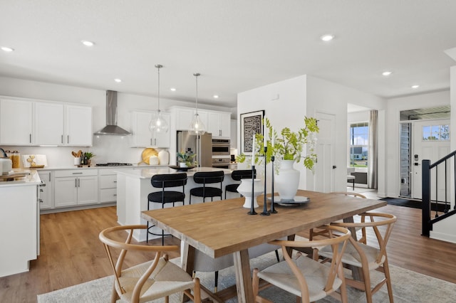 dining area featuring light wood-style floors, recessed lighting, and stairway