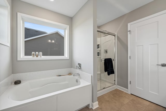 bathroom featuring a stall shower and a bath