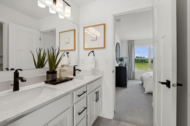 bathroom with tile patterned flooring, a sink, ensuite bath, and double vanity