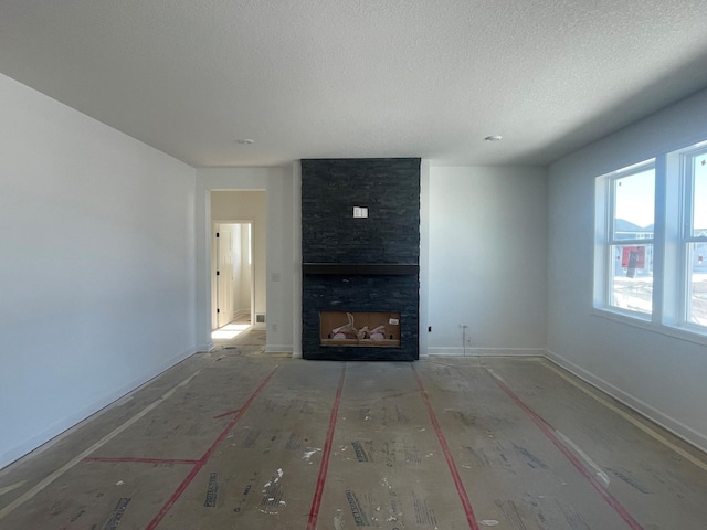 unfurnished living room featuring a fireplace and a textured ceiling