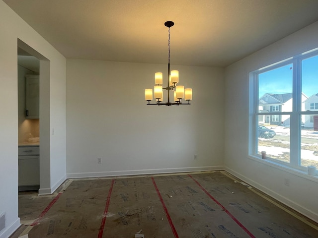 unfurnished dining area featuring visible vents, baseboards, and a notable chandelier