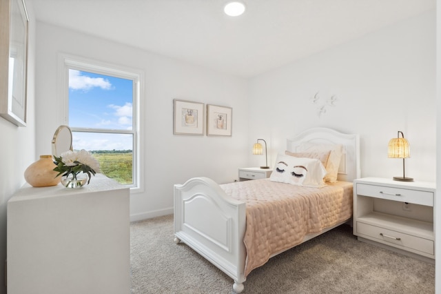 bedroom featuring light colored carpet and baseboards