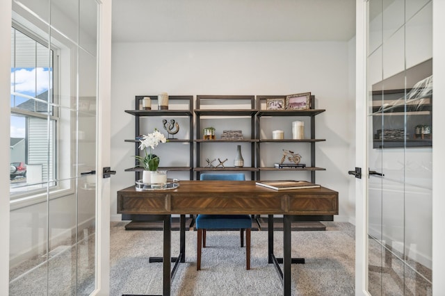 carpeted office space featuring french doors and baseboards