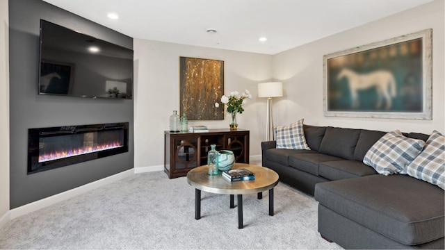 living area with recessed lighting, baseboards, a glass covered fireplace, and light colored carpet