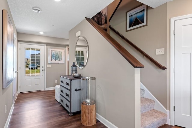 entryway featuring baseboards, a textured ceiling, stairway, and dark wood-style flooring