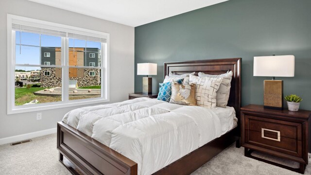 bedroom featuring baseboards, visible vents, and light colored carpet