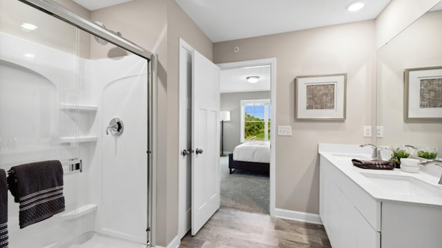 ensuite bathroom featuring a stall shower, double vanity, a sink, and ensuite bathroom