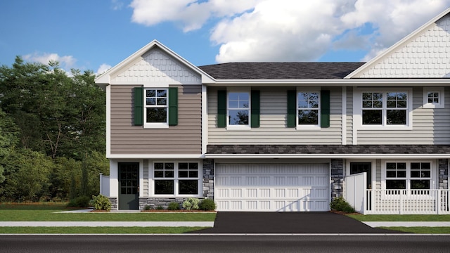 view of front of property with stone siding, roof with shingles, an attached garage, and driveway