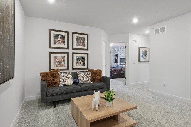 living room featuring light carpet, visible vents, and baseboards