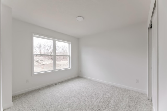 unfurnished bedroom with carpet flooring, visible vents, and baseboards