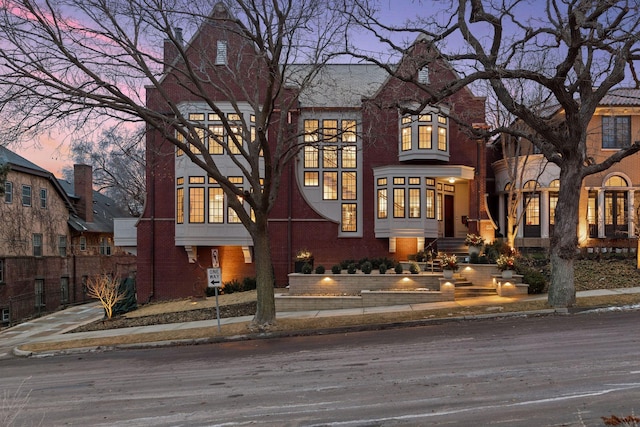 view of front of home with brick siding and fence