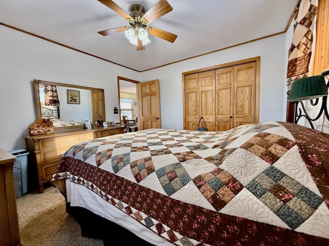 bedroom featuring ceiling fan, a closet, crown molding, and light colored carpet