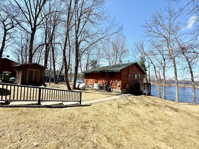 exterior space with a water view, an outbuilding, and a storage shed