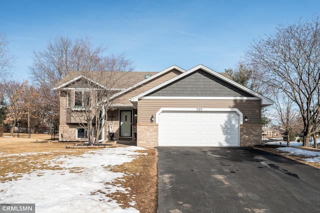 view of front of home featuring a garage, driveway, and brick siding