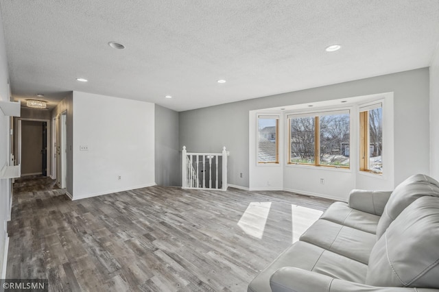 living room featuring baseboards, wood finished floors, and recessed lighting