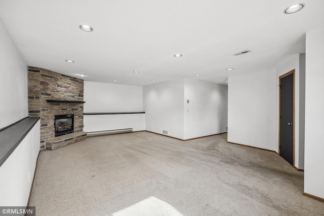 unfurnished living room featuring light carpet, visible vents, baseboard heating, and a stone fireplace