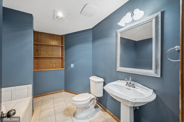 bathroom with a textured ceiling, tile patterned flooring, toilet, and baseboards