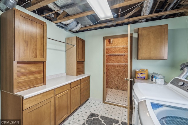 laundry area with light floors, cabinet space, and washer and dryer