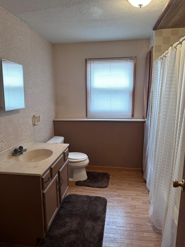 full bath featuring plenty of natural light, a textured ceiling, wood finished floors, and vanity