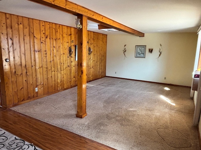 finished basement featuring carpet flooring, wood walls, and baseboards