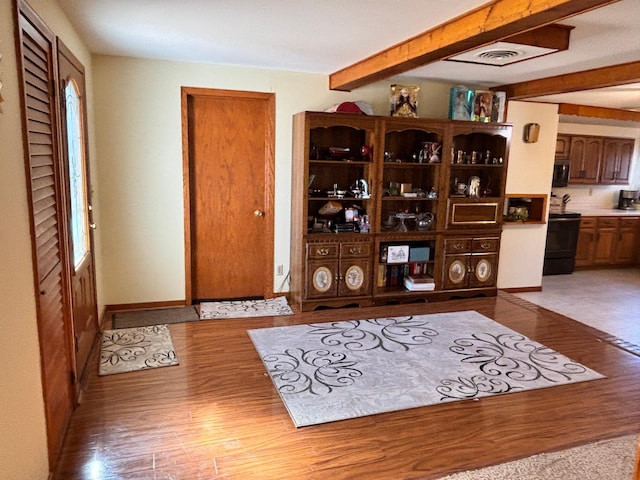 bar with beamed ceiling, stainless steel microwave, wood finished floors, and visible vents