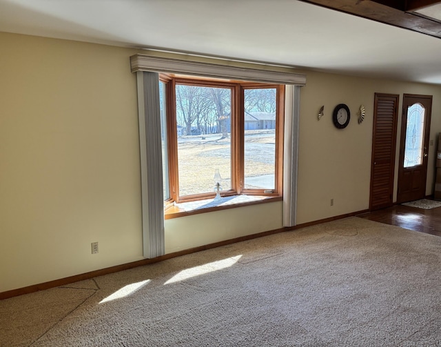 entrance foyer featuring dark carpet and baseboards