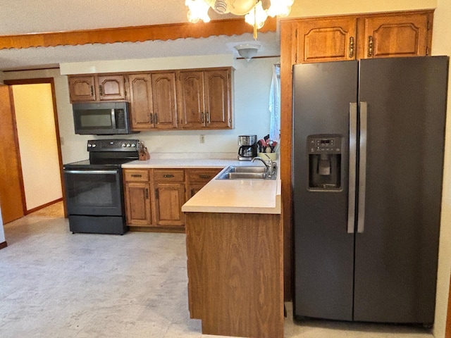 kitchen featuring brown cabinets, appliances with stainless steel finishes, light countertops, and a sink