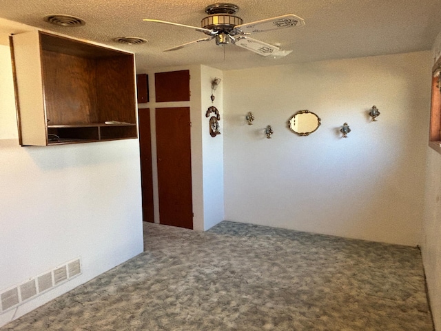 corridor featuring a textured ceiling, carpet, and visible vents