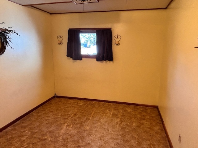 unfurnished room featuring carpet and baseboards