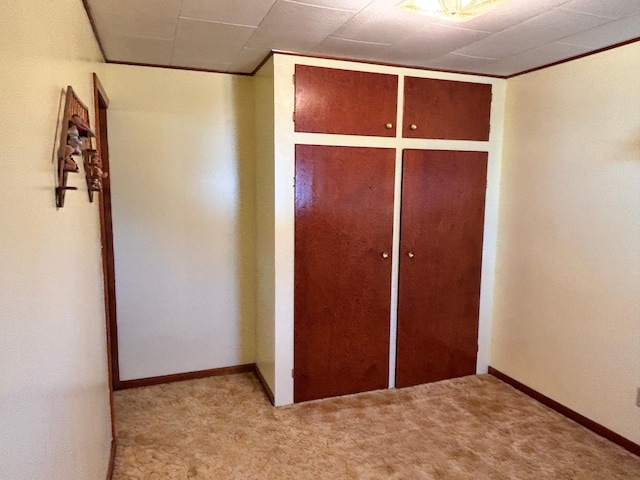 unfurnished bedroom with baseboards, a closet, and light colored carpet