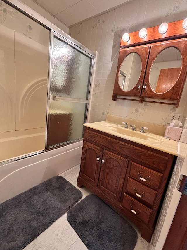 full bath featuring tile patterned flooring, shower / bath combination with glass door, and vanity