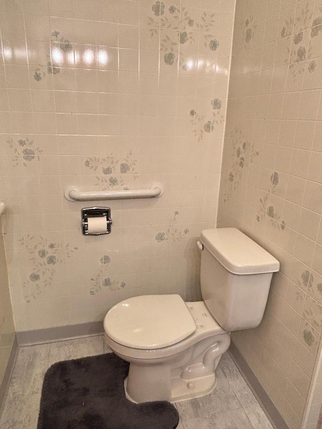 bathroom with tile walls and toilet