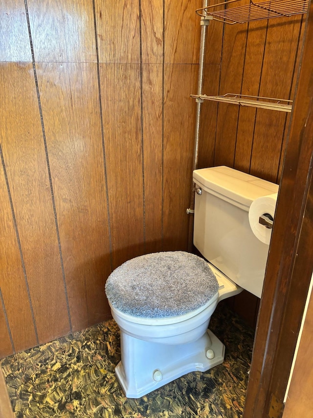 bathroom with toilet and wooden walls