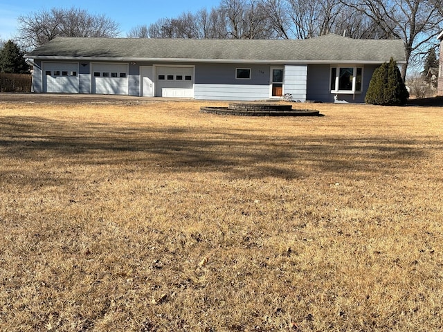 ranch-style house featuring a front yard, driveway, and an attached garage