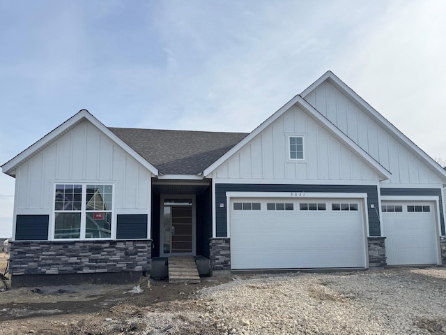 view of front of house featuring driveway, a shingled roof, board and batten siding, and an attached garage