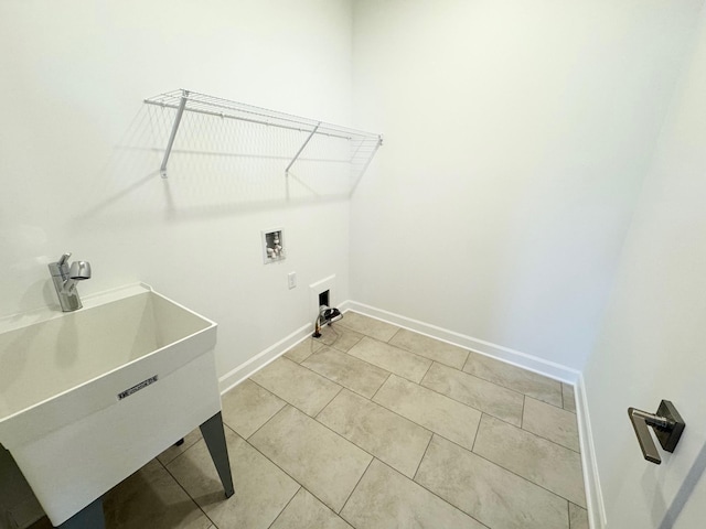 laundry area with washer hookup, light tile patterned flooring, a sink, laundry area, and baseboards