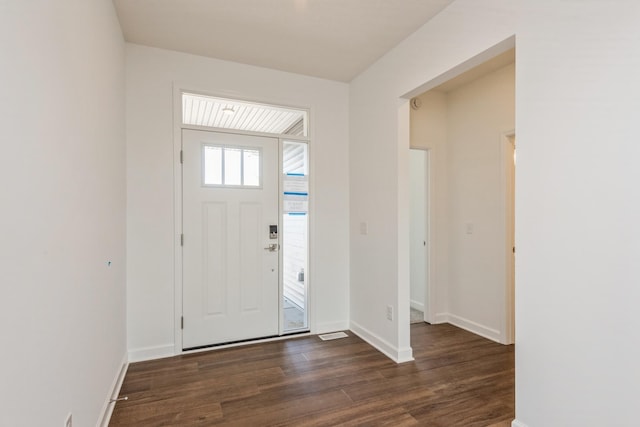 foyer with dark wood-type flooring and baseboards