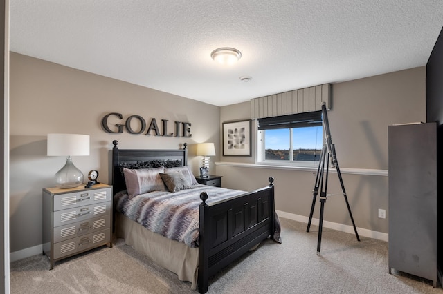 bedroom with light carpet, a textured ceiling, and baseboards