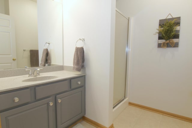 full bath with a shower stall, vanity, and baseboards