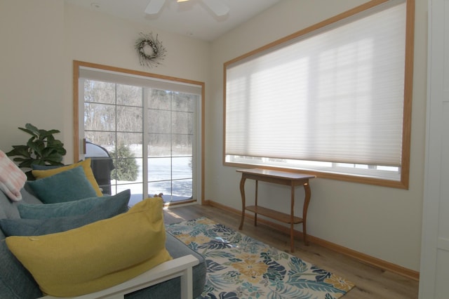 sitting room with ceiling fan, baseboards, and wood finished floors