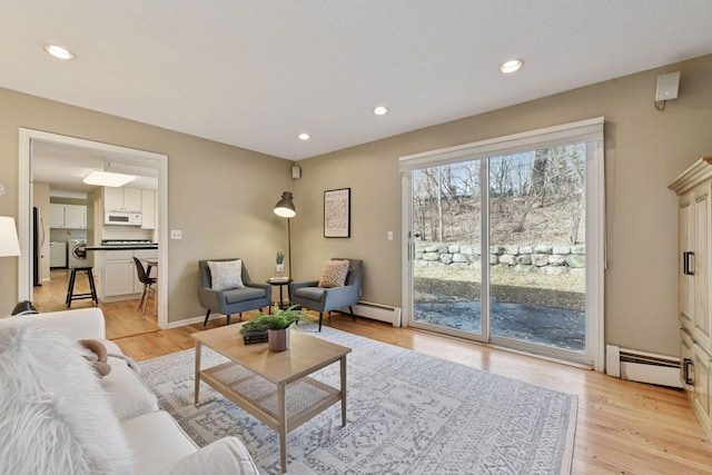 living area with recessed lighting, light wood-type flooring, and baseboard heating