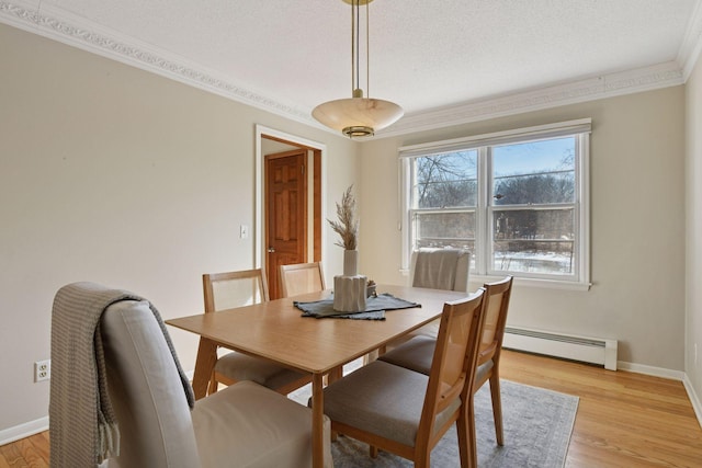 dining space featuring baseboard heating, a textured ceiling, baseboards, and light wood-style floors