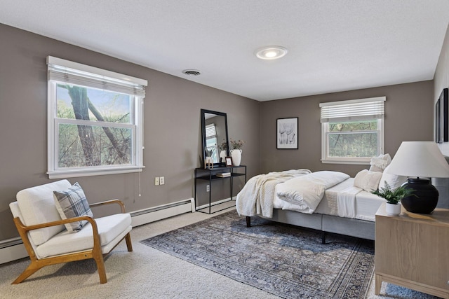 carpeted bedroom with a baseboard radiator, multiple windows, and visible vents