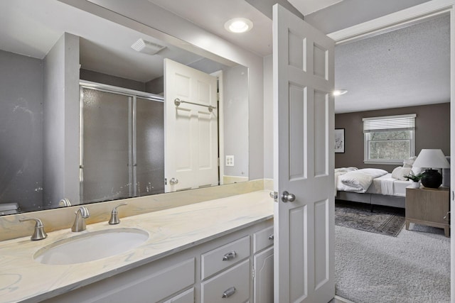 bathroom with vanity, visible vents, a stall shower, a textured ceiling, and connected bathroom