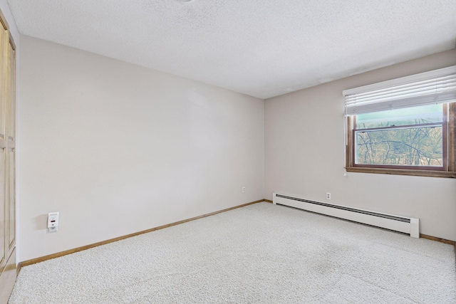 spare room with baseboards, light carpet, baseboard heating, and a textured ceiling